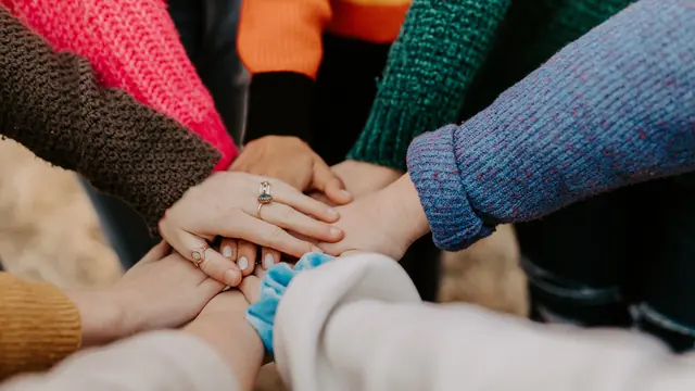 Hands joined in a recovery support group