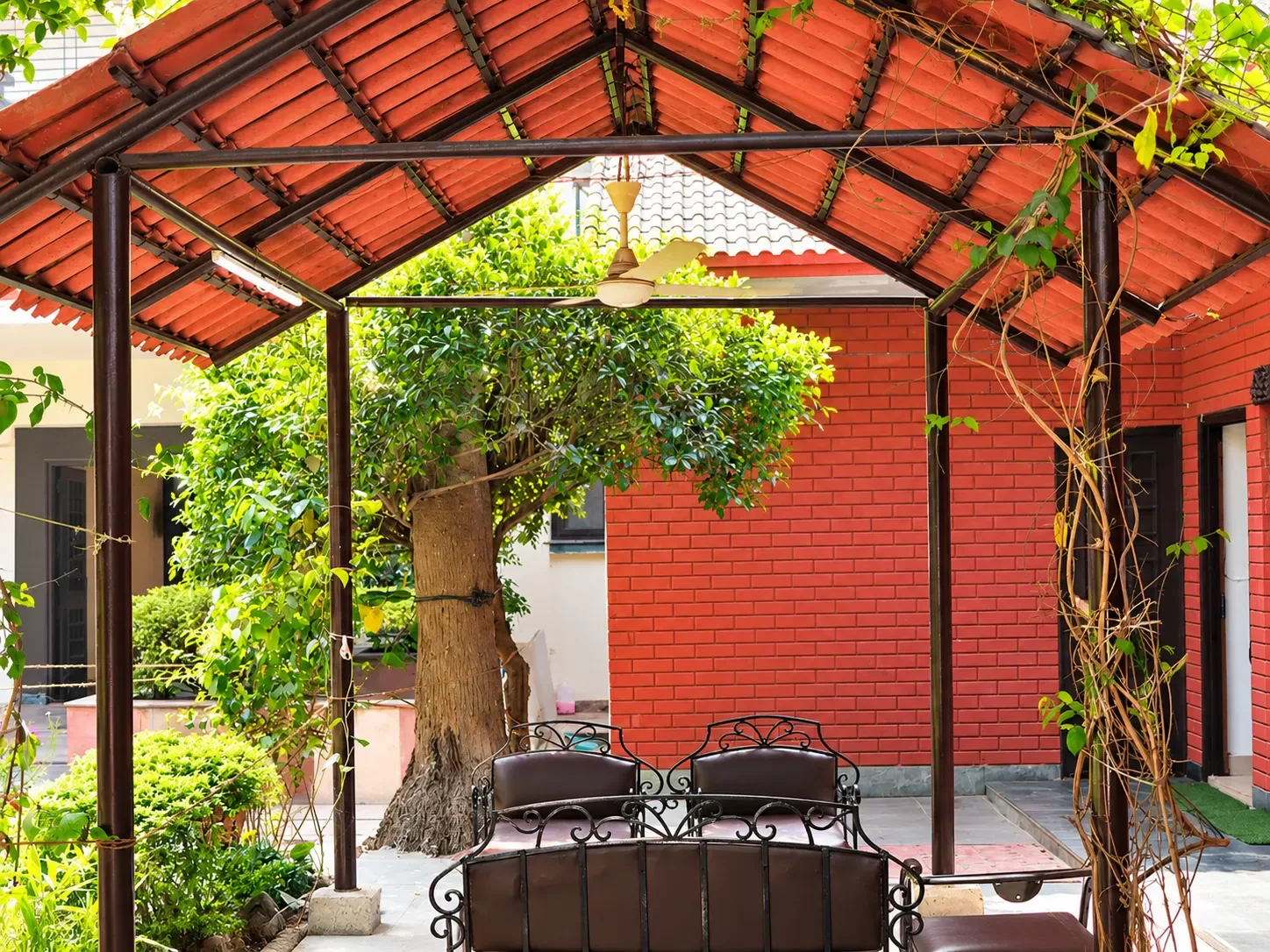 A covered garden seating area with a red tiled roof at the Delhi Women&rsquo;s Center