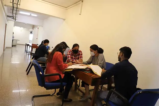 A group session around a table at the Gurugram centre