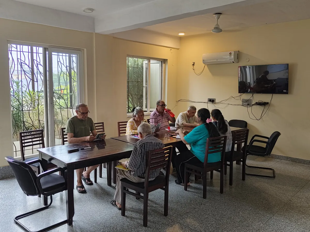 Residents and a counsellor sharing a meal together at the Mehrauli centre