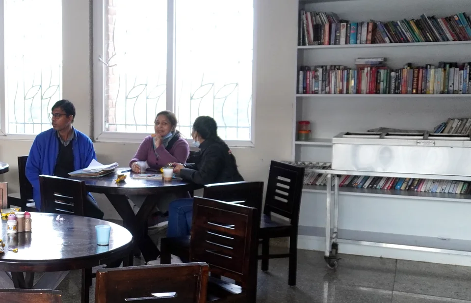 Residents reading and talking together in the library at the Gurugram centre